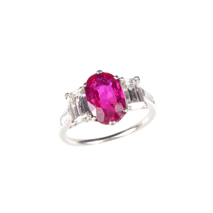 Ruby and diamond three stone ring, claw set with an oblong Burma ruby.
